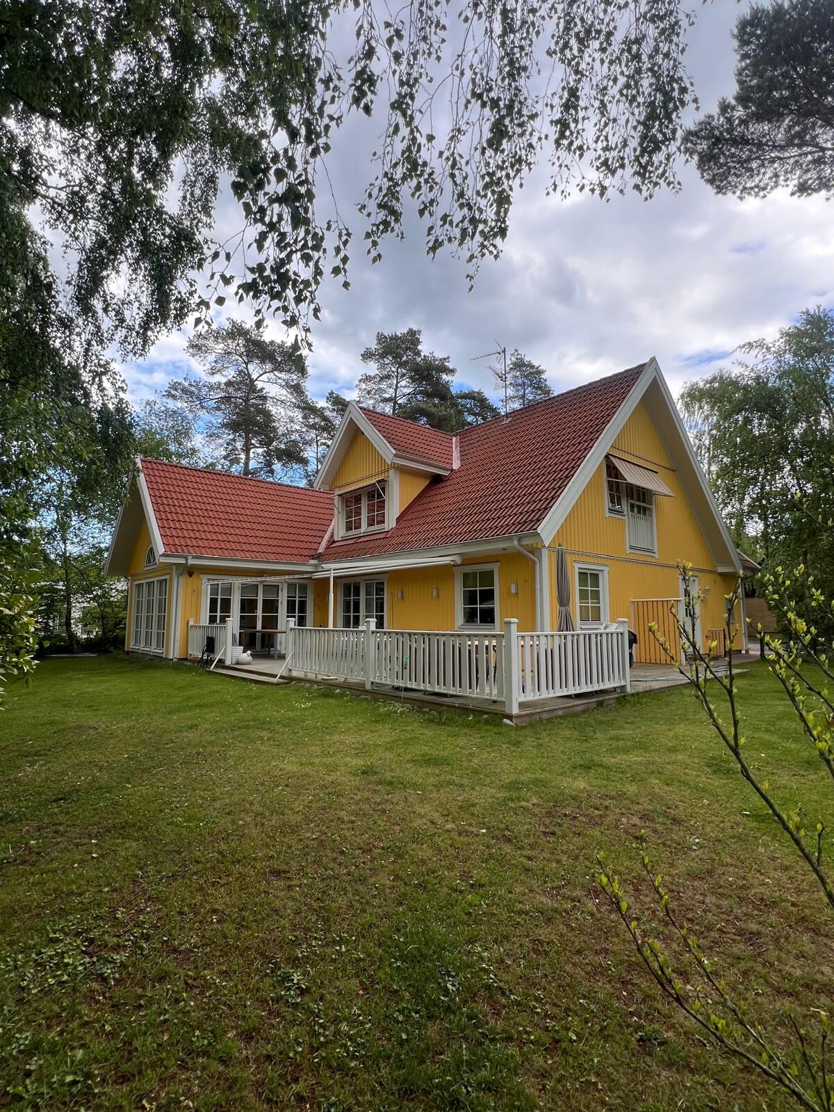 Färdigmålad gul villa med vita fönsterfoder efter utvändig målning